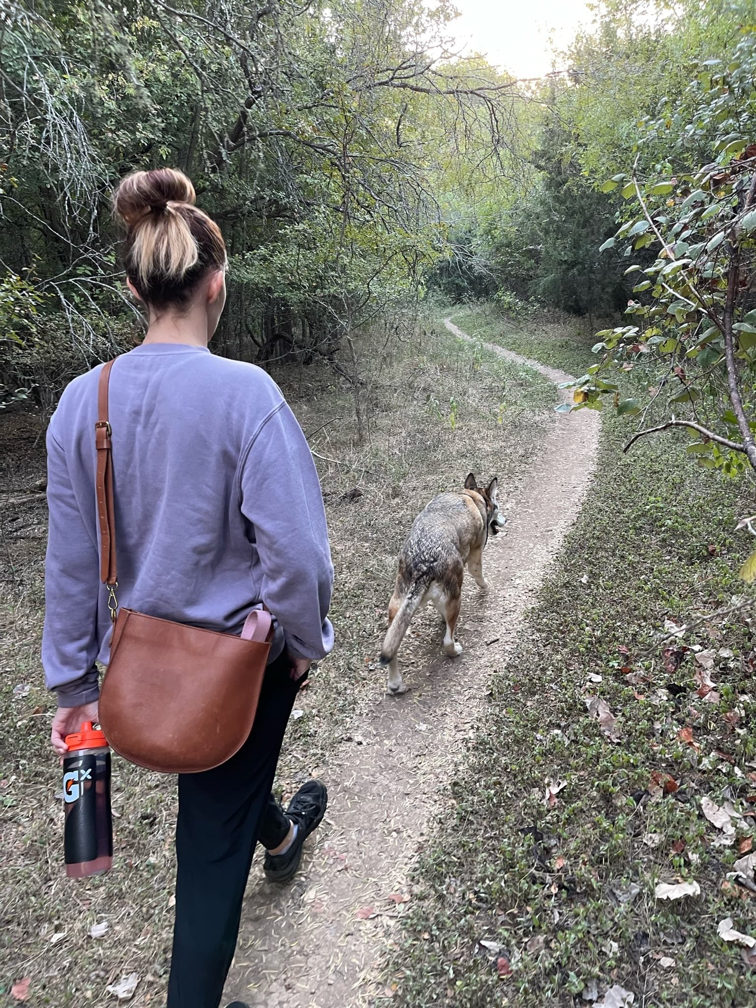 female on walking trail with old dog