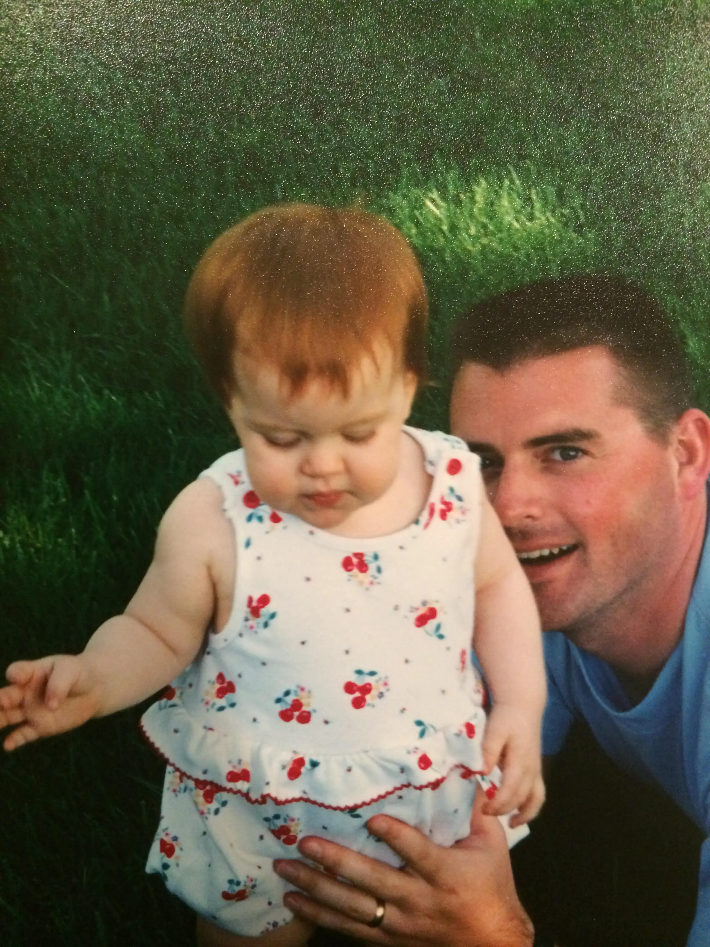 while male helps infant daughter stand up