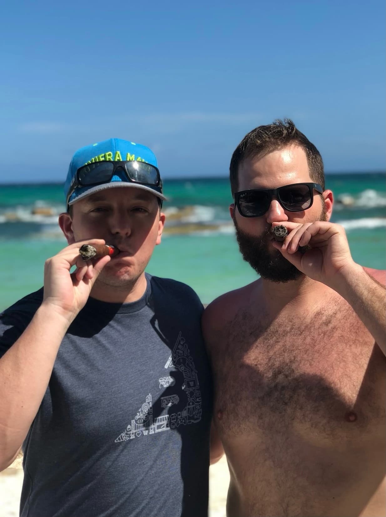 Two friends smoking cigars on a sunny beach