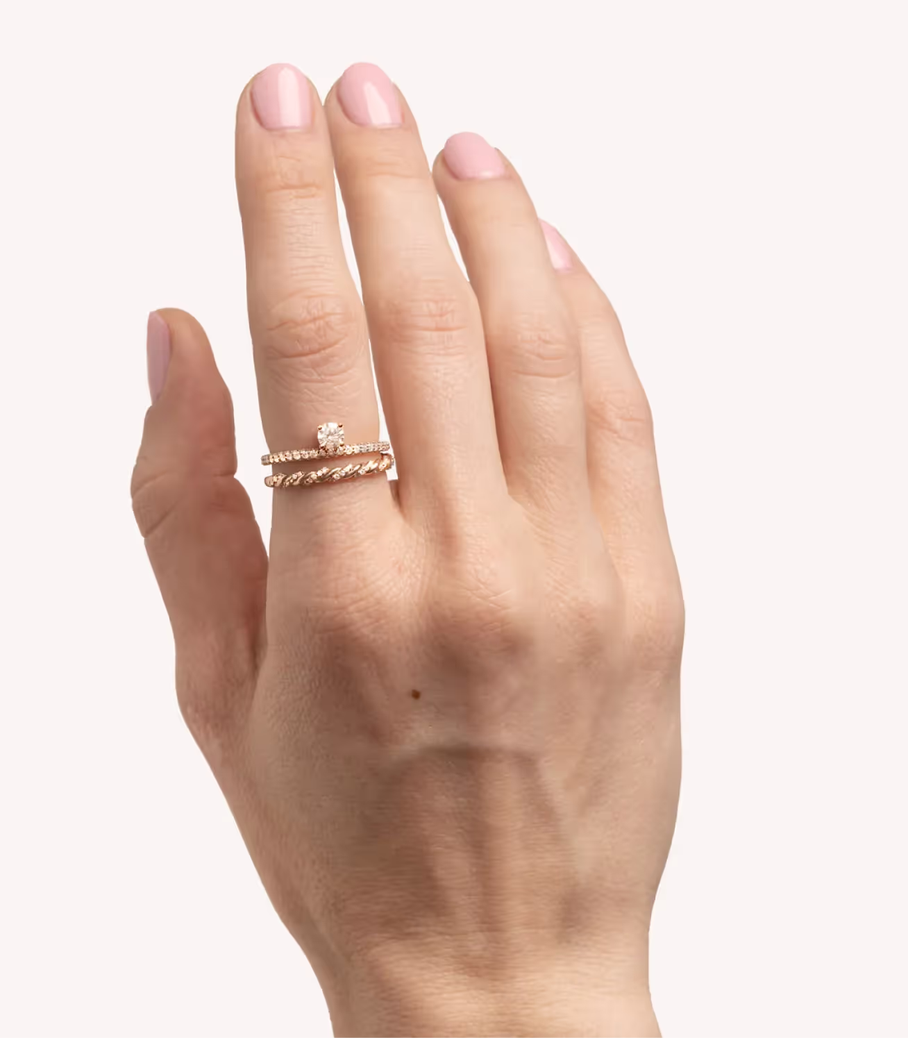 A hand resting on a white background, wearing a memorial diamond ring.
