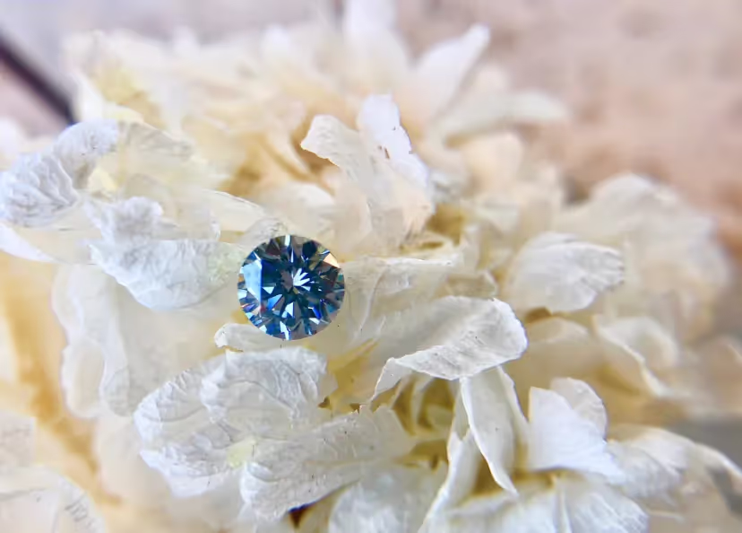 A gorgeous blue round diamond on white flowers.