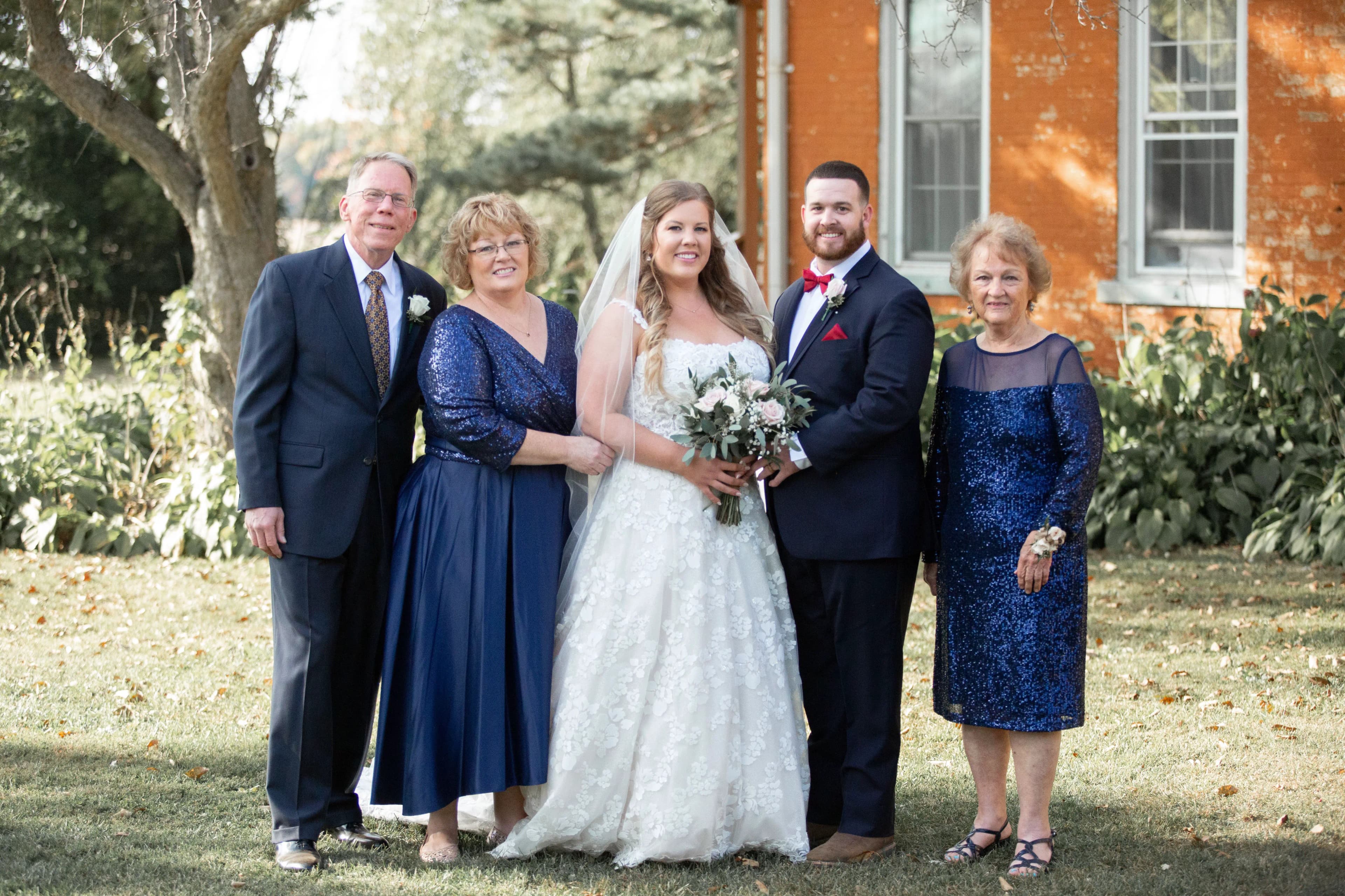Erin and Zach on their wedding day, posing with family members.