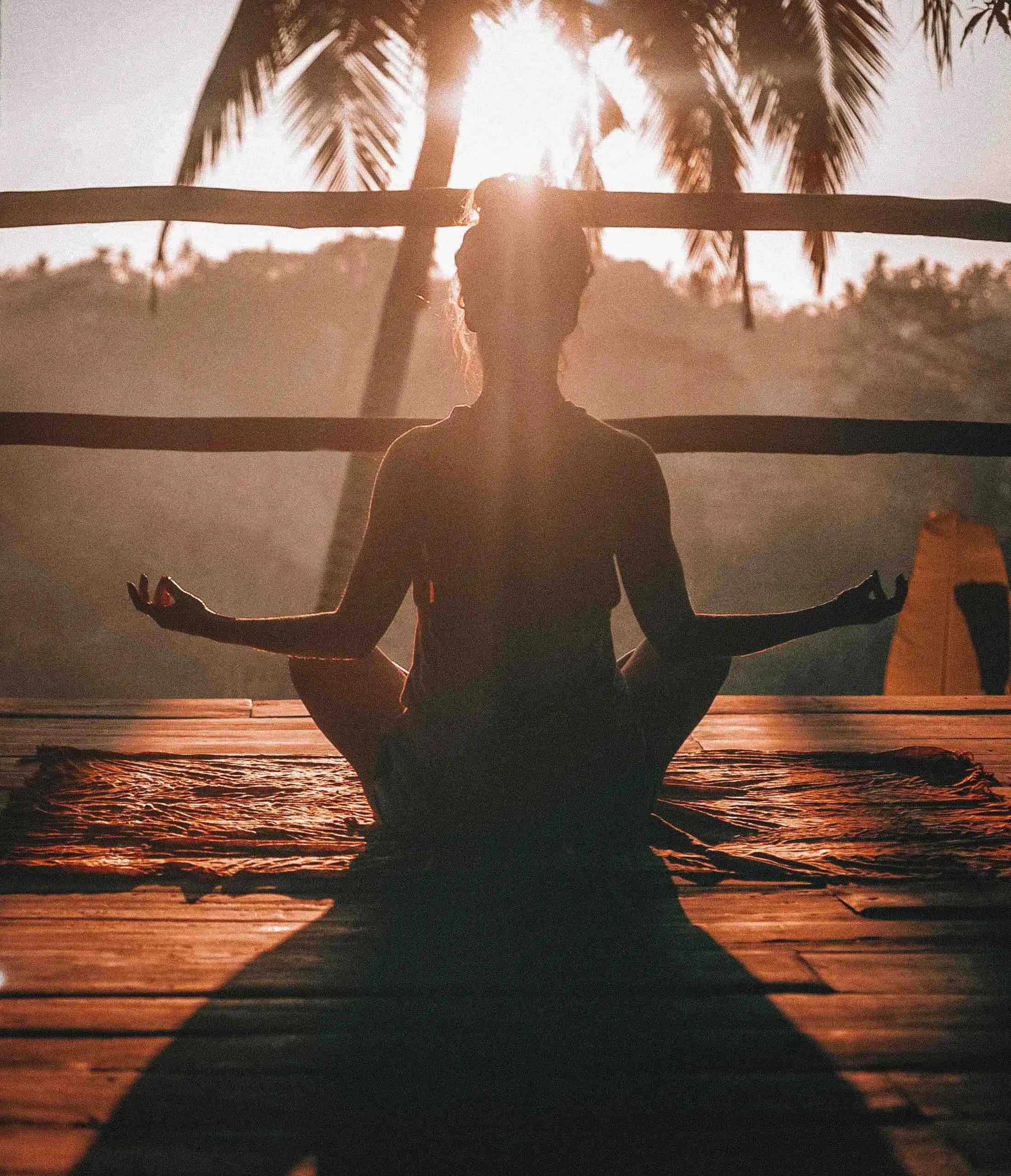 a woman meditates at sunrise