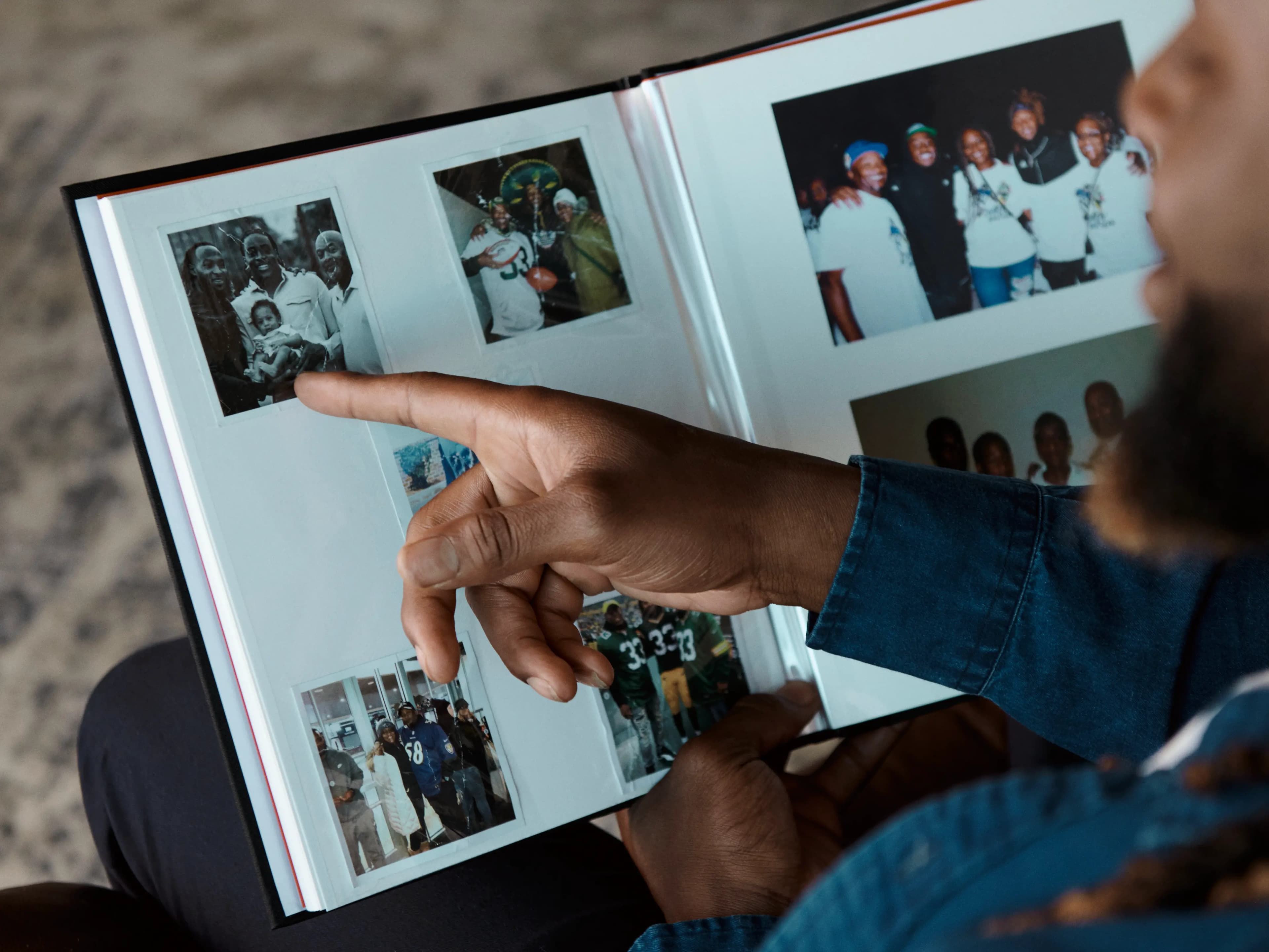 A person points to family photos in an open album.