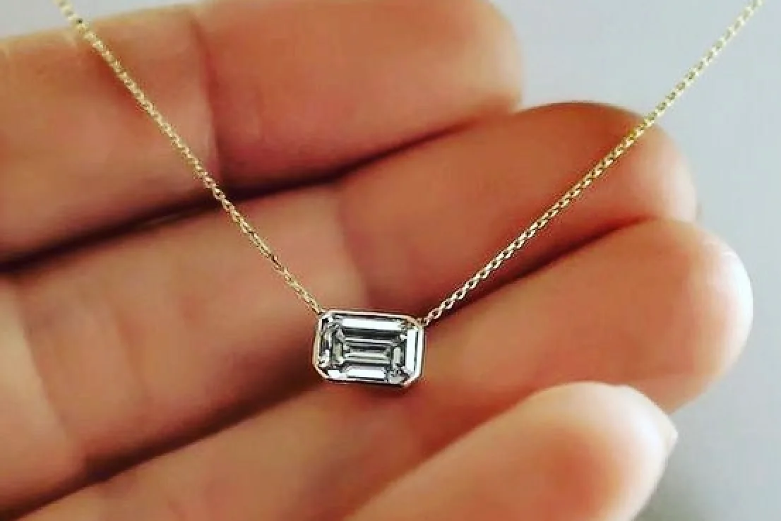 Diamond necklace in person's hand.