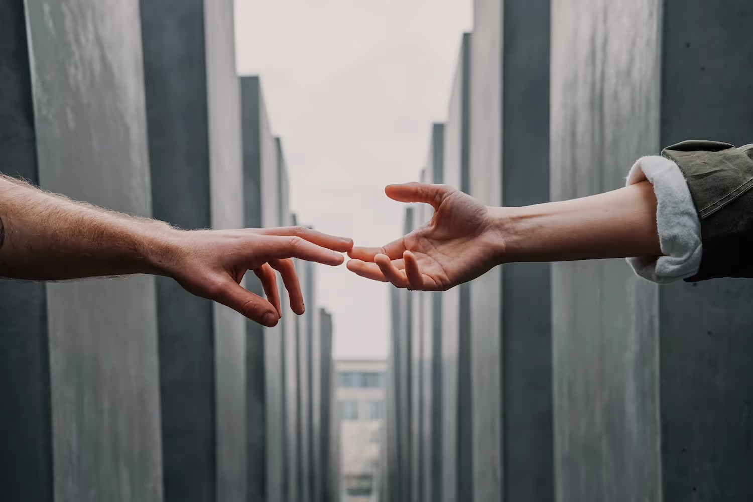 Hands reaching for each other across a gap.