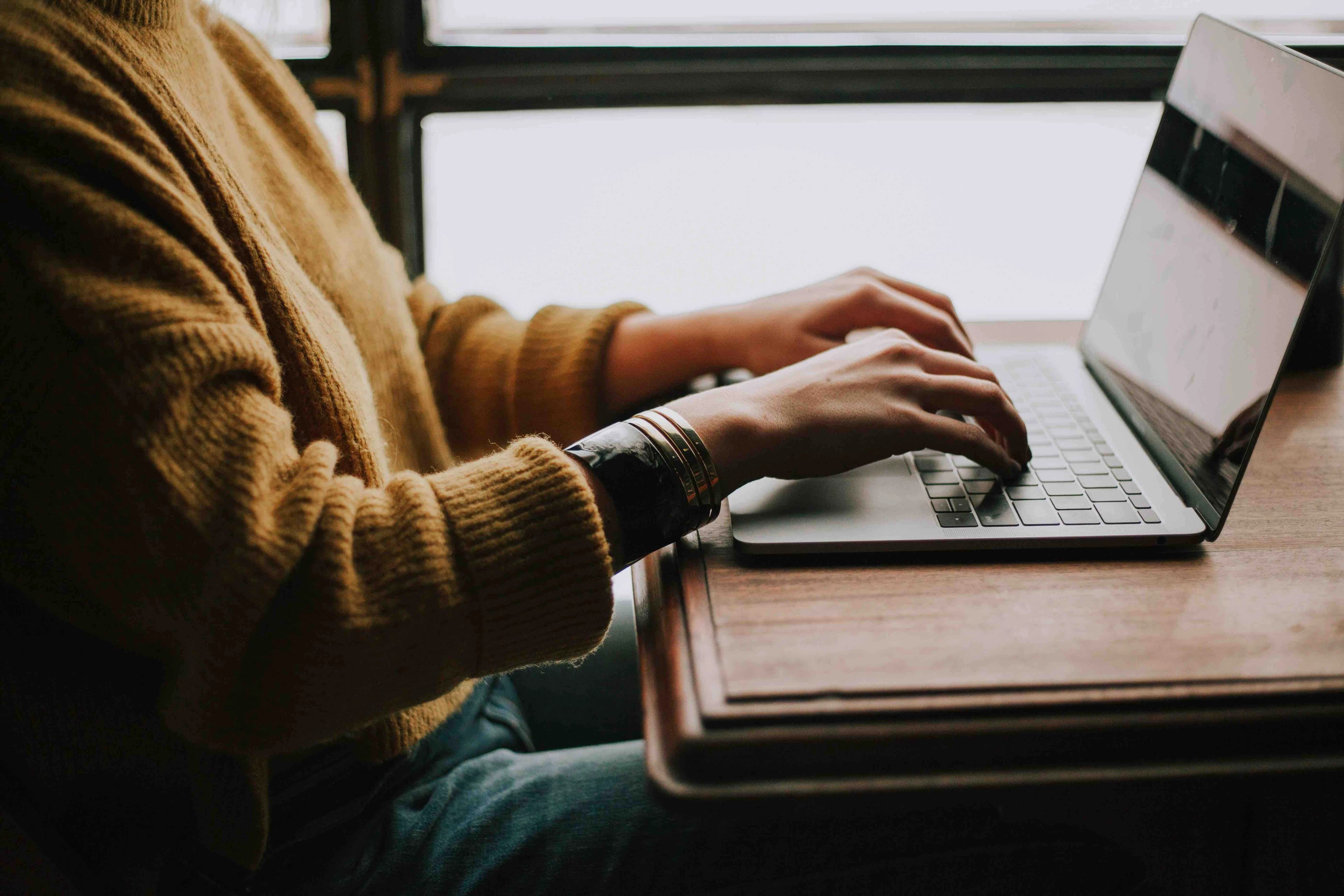 hands typing on laptop