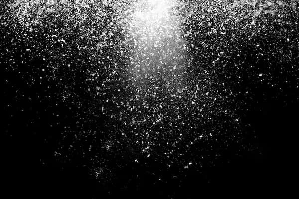Abstract black artwork covered in fine white specks, like scattered ash or stars.