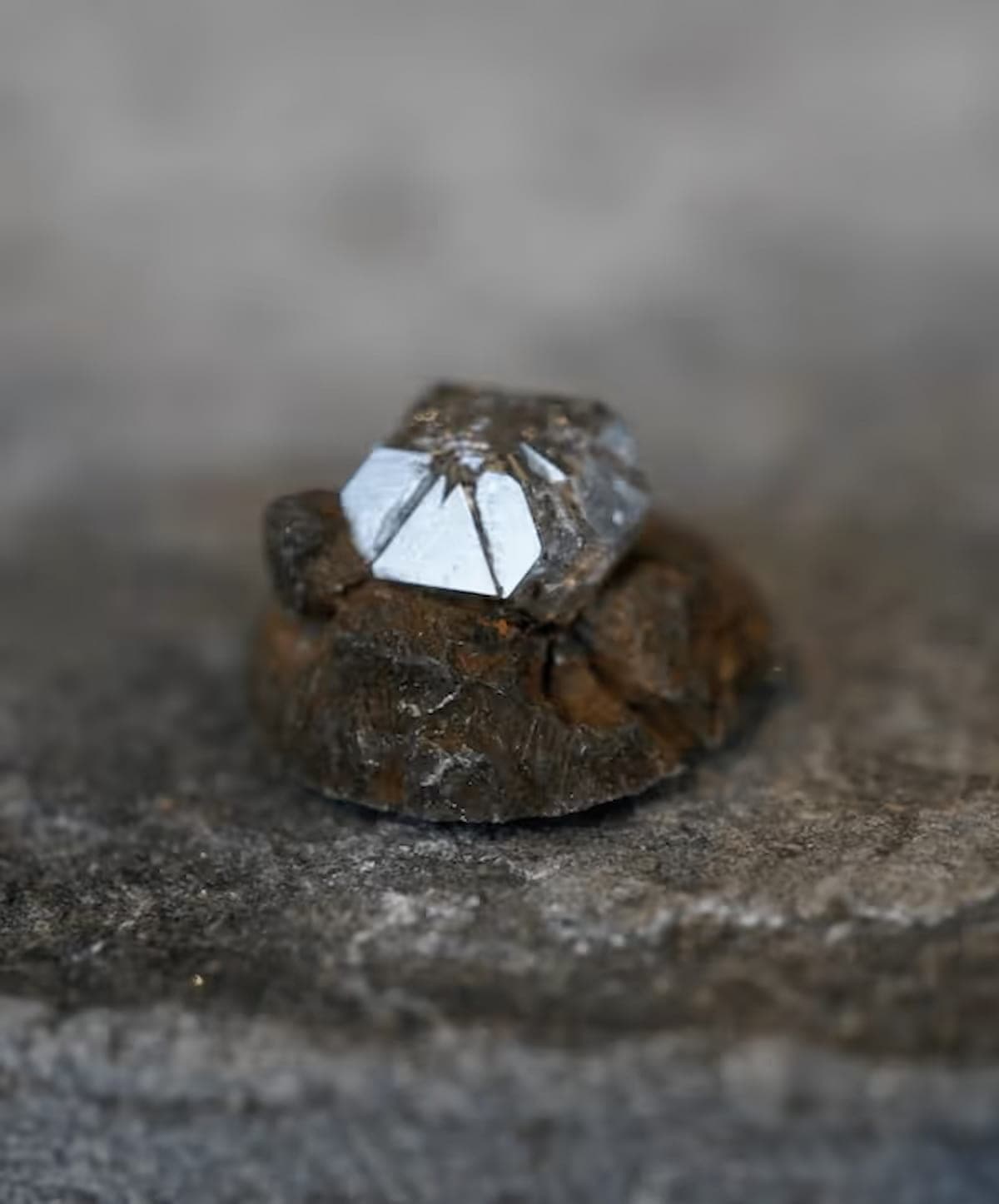 Close-up of a rough uncut diamond still partially embedded in its growth material, showing the natural crystal shape before cutting.