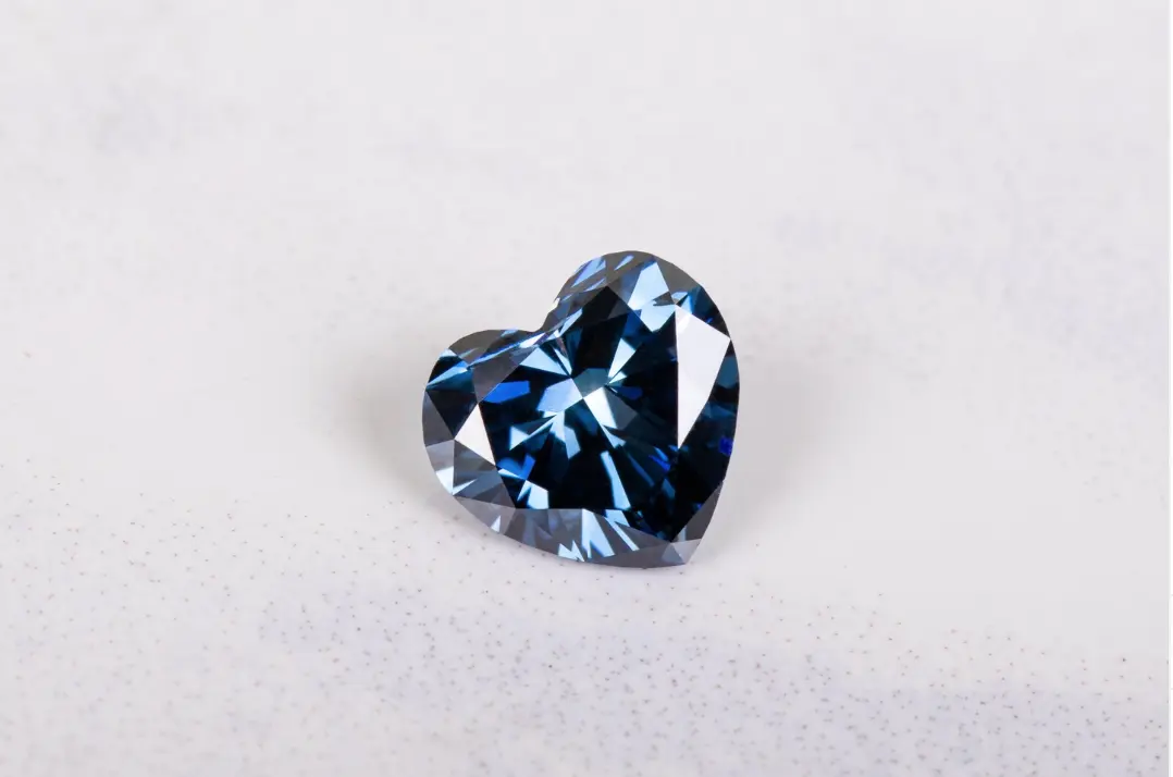 Deep blue heart-shaped diamond on a white surface